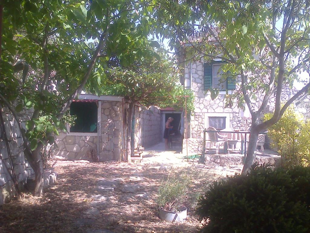osoba stojąca w drzwiach kamiennego domu w obiekcie Art House Old Village w mieście Jesenice
