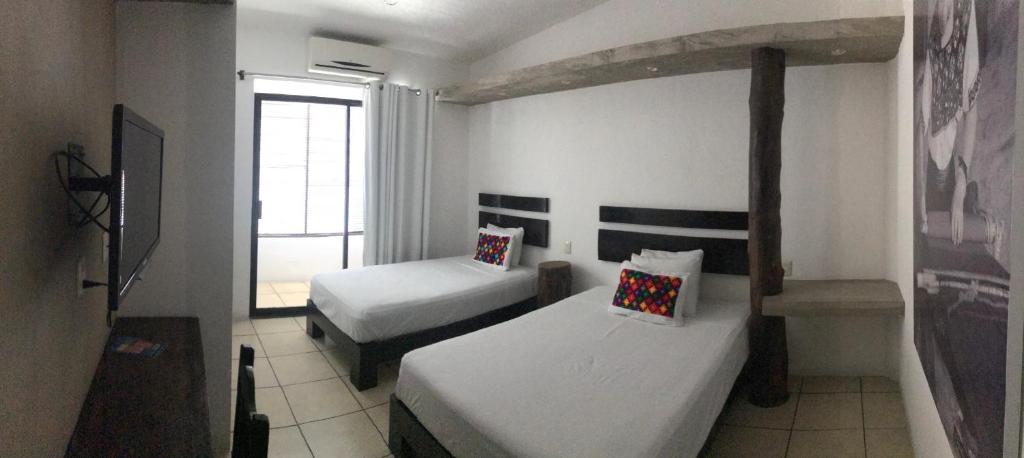 Postel nebo postele na pokoji v ubytování Hotel Maya Rue