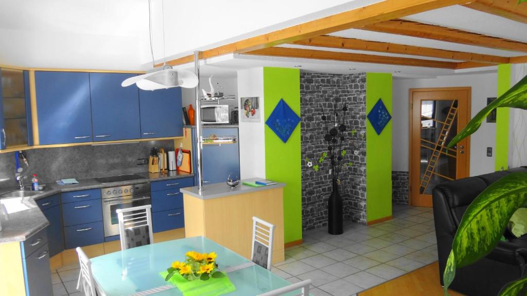 cocina con armarios azules y paredes verdes en FEWO-Frammersbach en Frammersbach