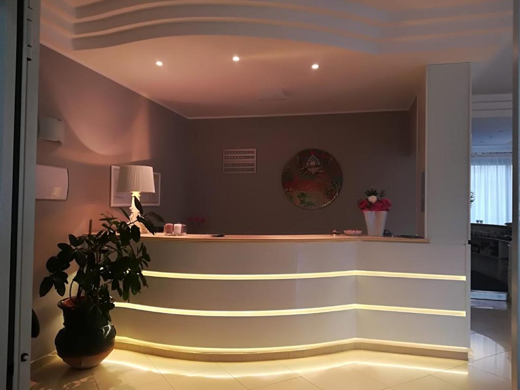 a lobby with a counter with a potted plant at Bikini Hotel in Vieste