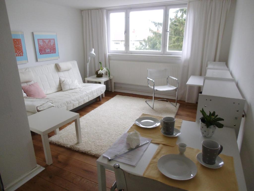 Ferienwohnung am Schloss في كارلسروه: غرفة معيشة مع أريكة بيضاء وطاولة