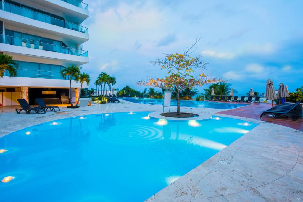 uma piscina com uma árvore em frente a um edifício em Sonesta Hotel Cartagena em Cartagena das Índias