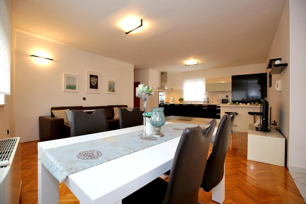 - une salle à manger et un salon avec une table et des chaises blanches dans l'établissement City Gallery Apartment, à Zadar