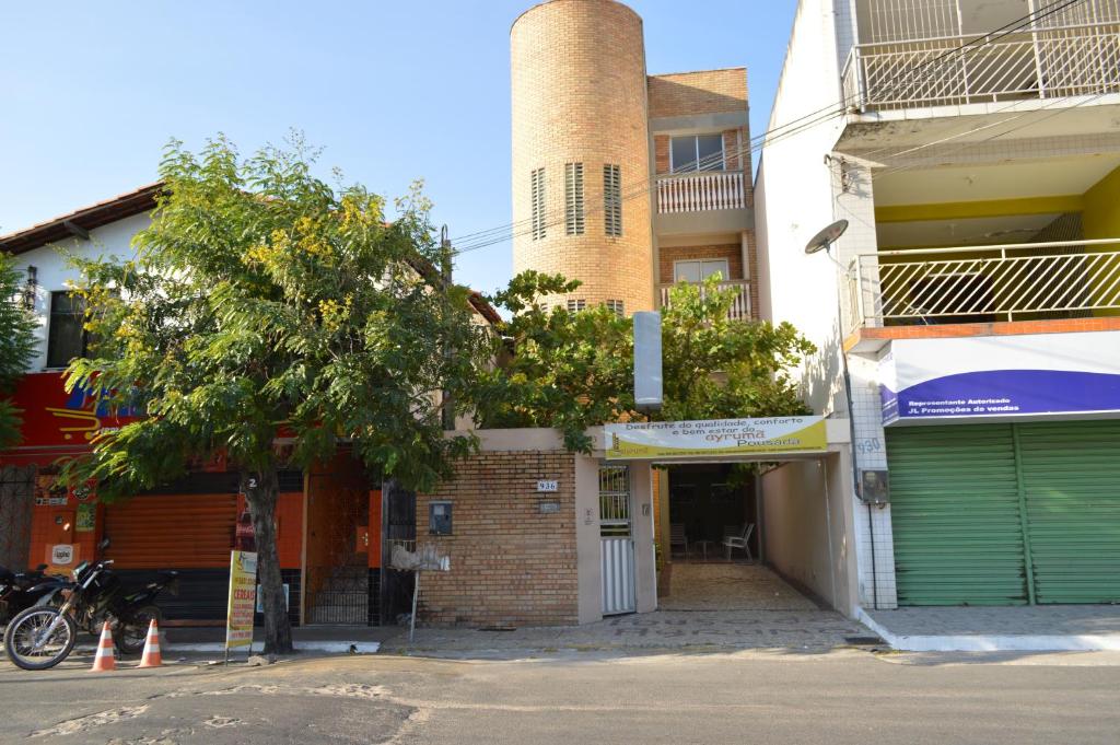 a brick building with a tall tower on a street at Pousada Ayrumã in Itapipoca