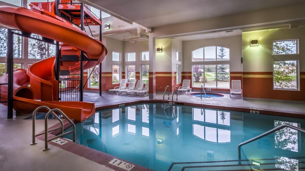 a swimming pool with a slide in a building at Service Plus Inns and Suites Calgary in Calgary