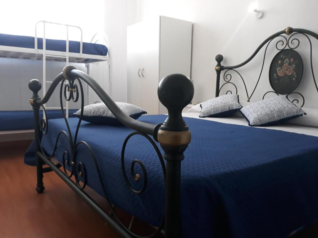 sypialnia z łóżkiem z niebieską kołdrą w obiekcie La Casetta alla Tonnara w mieście Milazzo