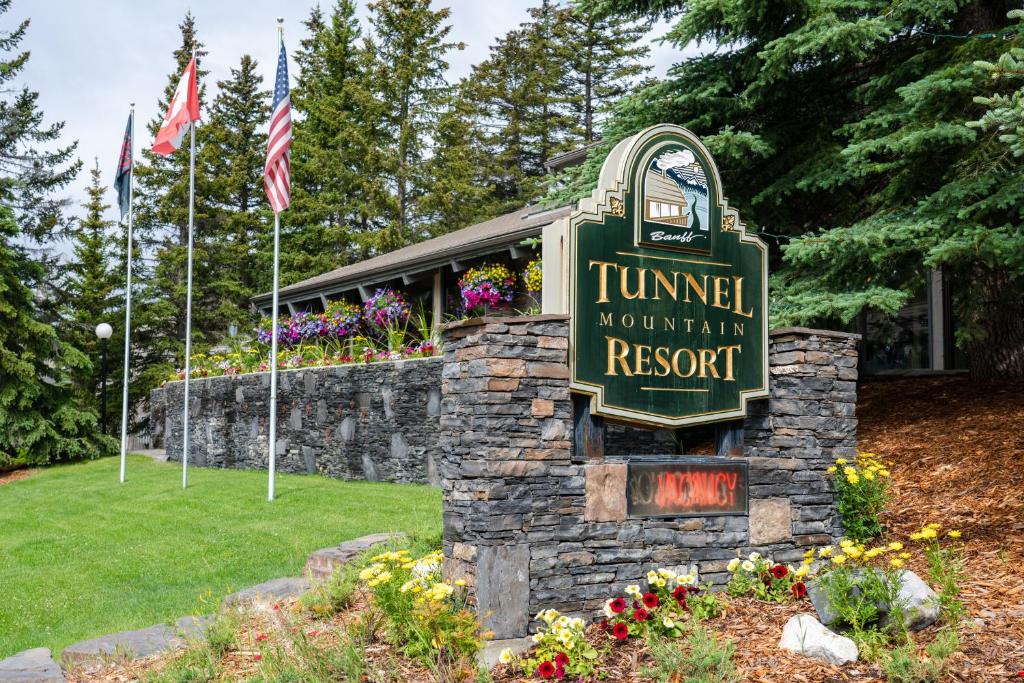 una señal para un complejo de montaña tumnell con banderas en Tunnel Mountain Resort, en Banff