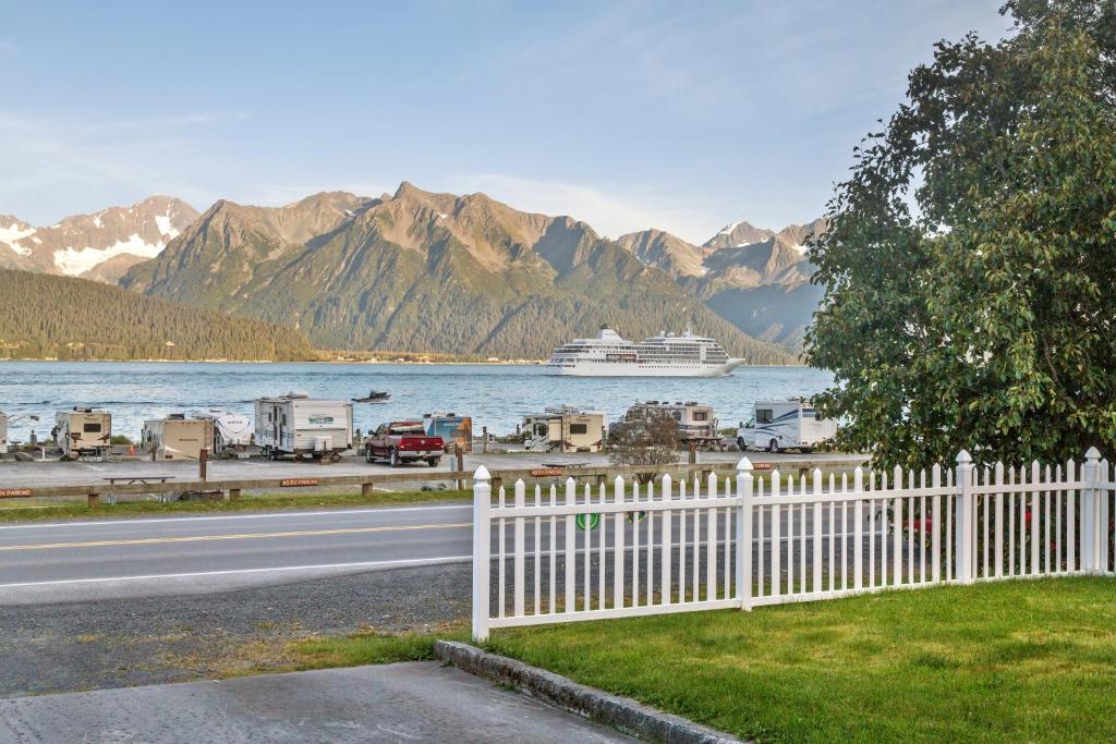 a white fence with a cruise ship in the water at Alaska's Point of View in Seward