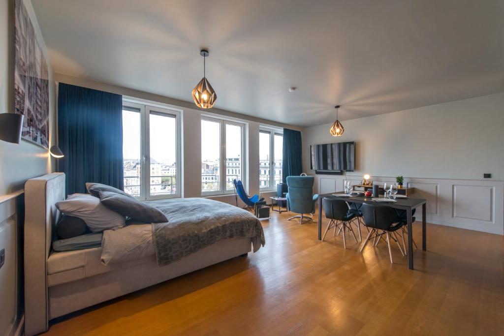 a bedroom with a bed and a desk and a dining room at Studio des princes in Liège