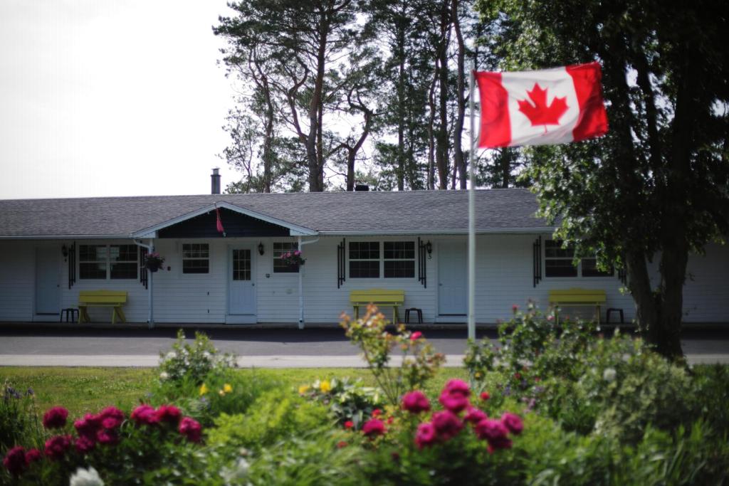 una bandera canadiense ondeando delante de una casa en CARLETON INN & COTTAGES, en Bridgetown