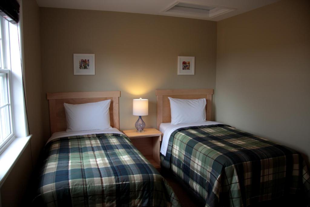 two beds sitting next to each other in a room at CARLETON INN & COTTAGES in Bridgetown