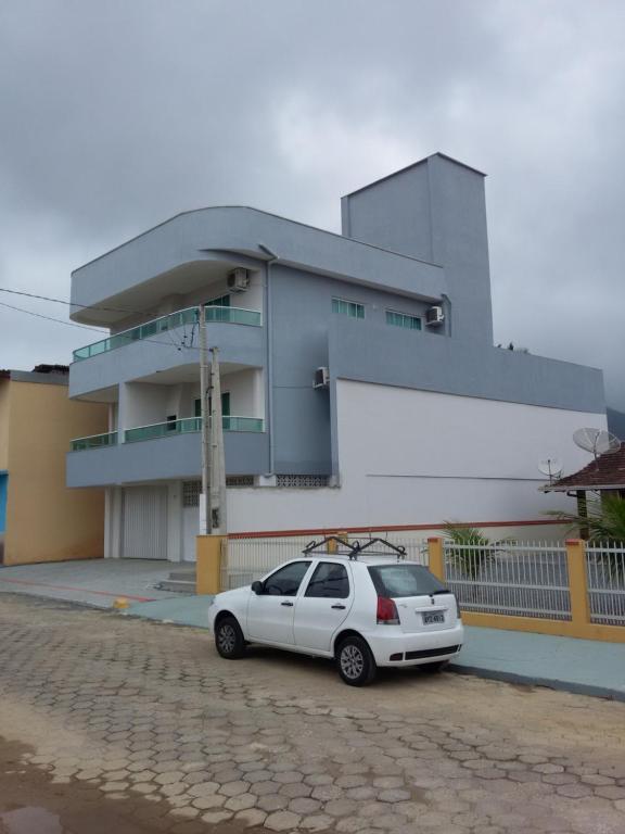 un coche blanco estacionado frente a un edificio en Residencial Corrêa, en Penha