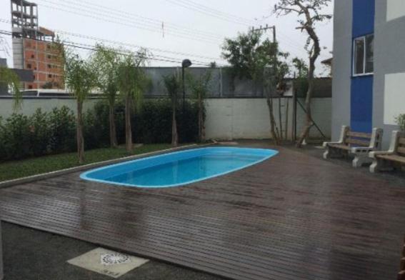 una pequeña piscina azul en medio de un patio en Apartamento em Penha SC, en Penha
