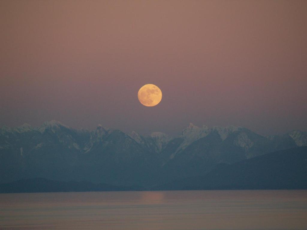 a full moon rising over a mountain range at Gibralter Rock Ocean View B&B in Nanaimo