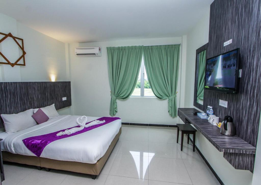 a bedroom with a large bed and a television in it at Salsa Resort Langkawi By Casa Loma in Pantai Cenang