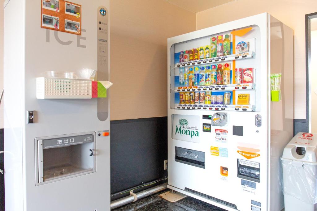 a large white refrigerator with many magnets at Condominium Hotel Monpa in Chatan