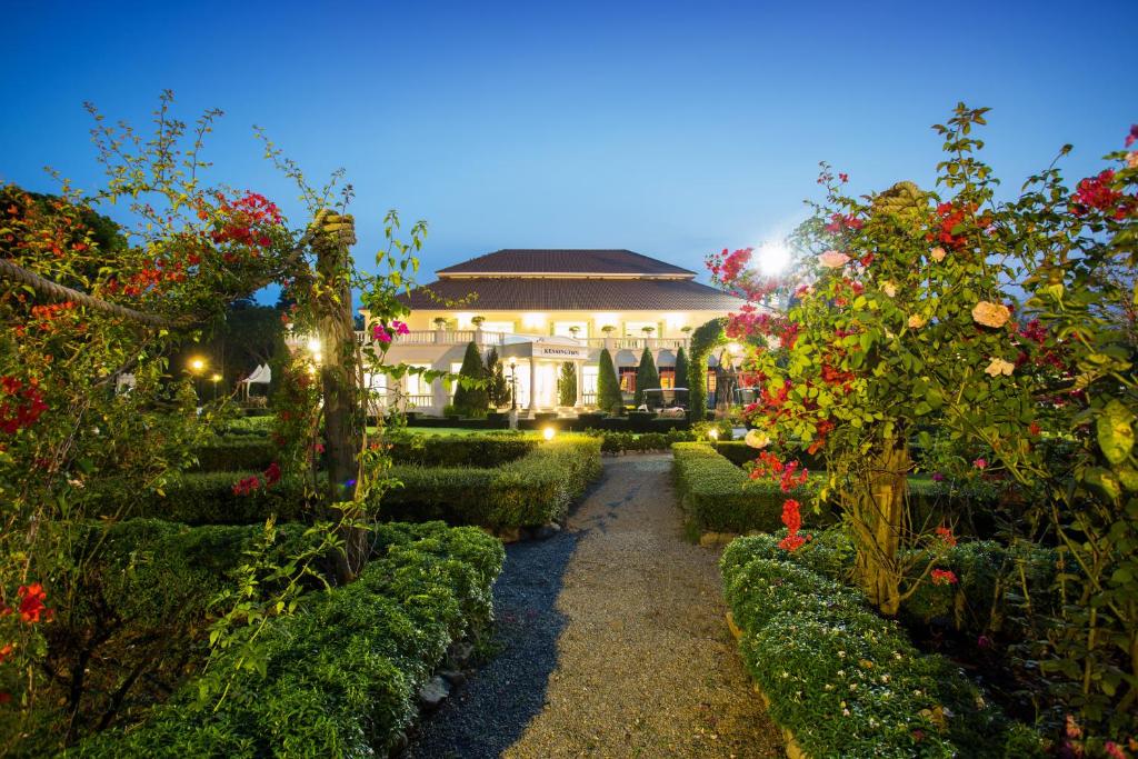 um jardim com flores e um edifício ao fundo em Kensington English Garden Resort Khaoyai em Wangkata