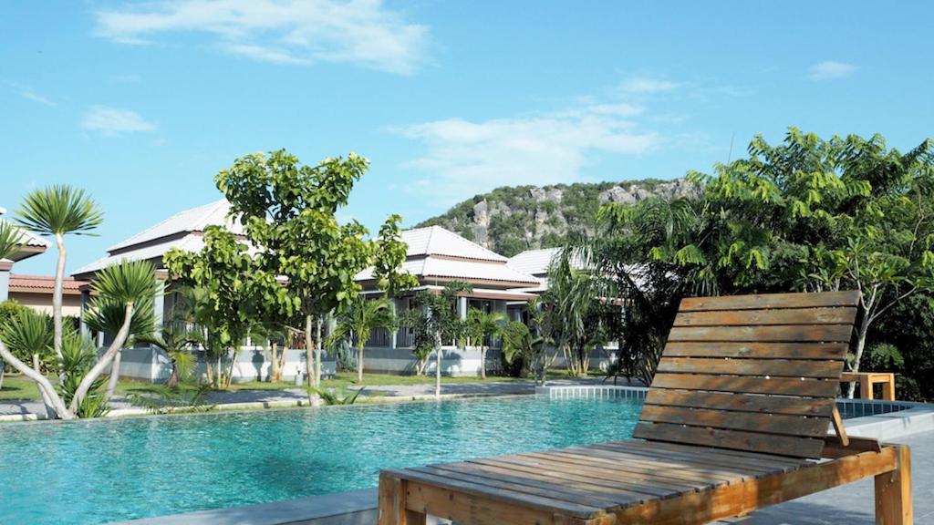 盼武里的住宿－KP山海灘酒店，游泳池旁的木凳