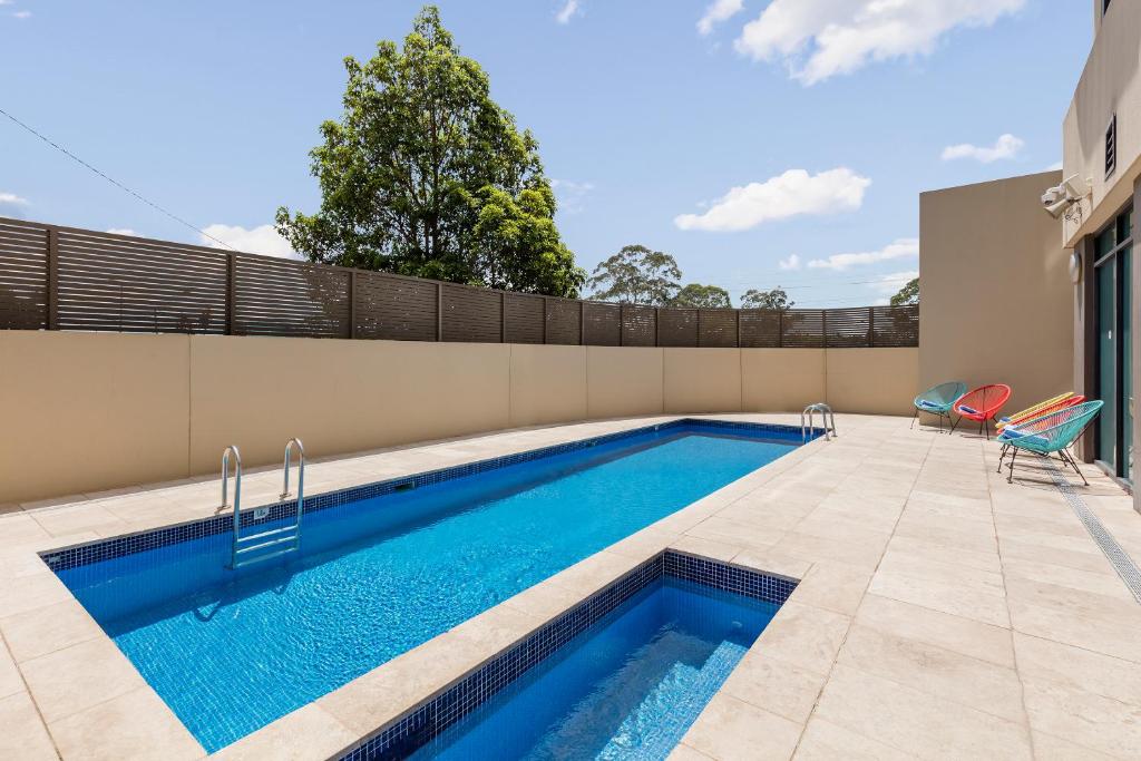 a swimming pool with blue water in a house at Nesuto Parramatta in Sydney