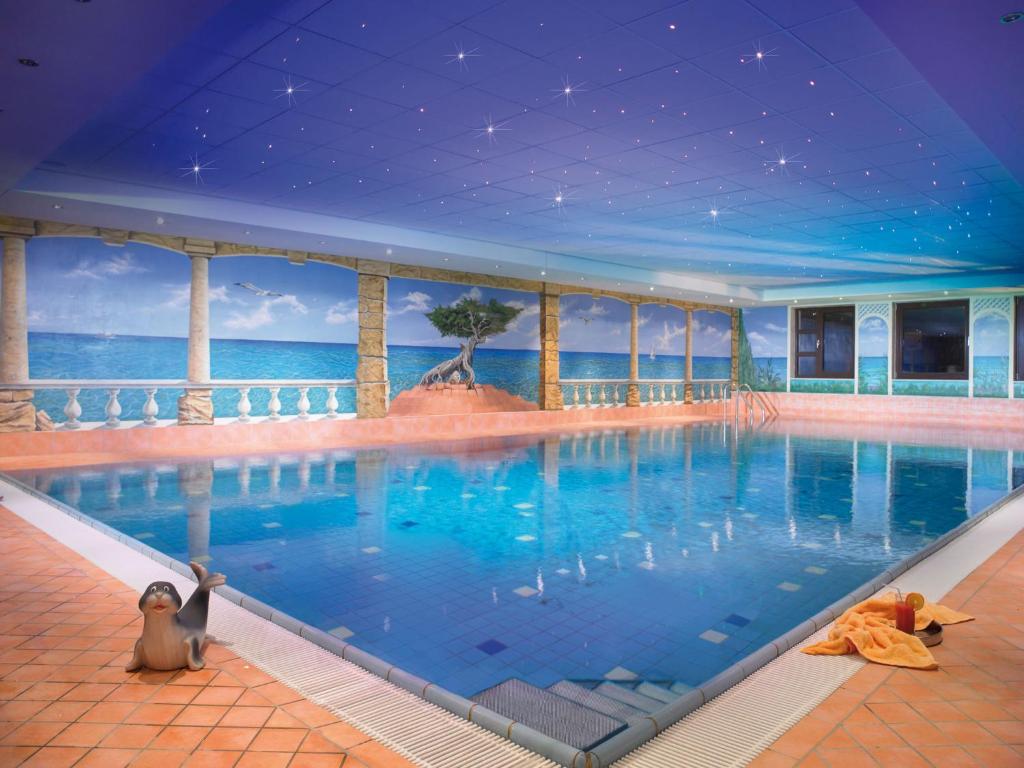 ein Swimmingpool mit Blick auf das Meer in der Unterkunft Sporthotel Göbel Garni in Willingen