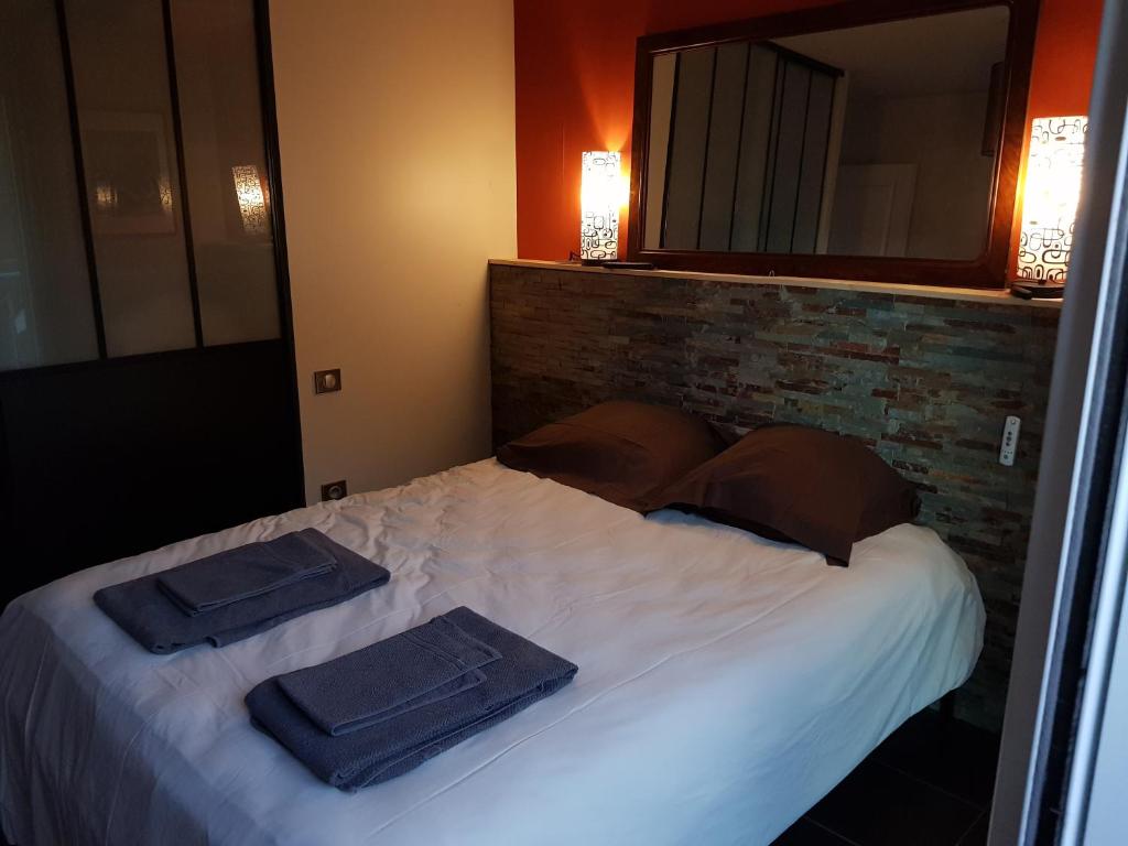 1 dormitorio con 1 cama con 2 toallas en Les Bruyères en Civrieux-dʼAzergues