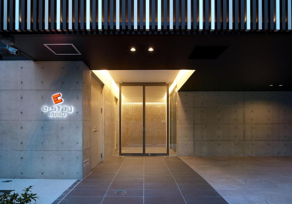 una entrada a un edificio con una puerta de cristal en e-stay ebisu, en Osaka