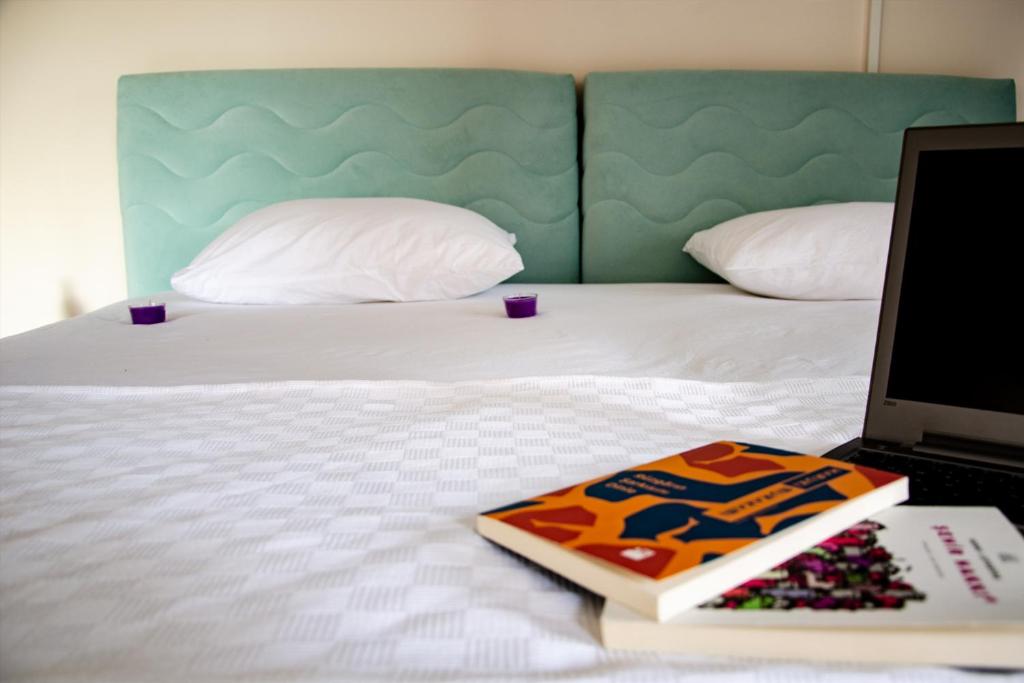 a bed with a laptop and a book on it at Venüs Pansiyon in Canakkale