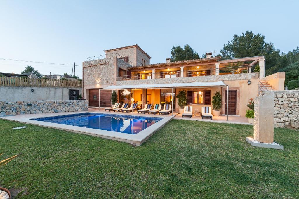 une maison avec une piscine dans la cour dans l'établissement CA NA VINGA, à Alcúdia