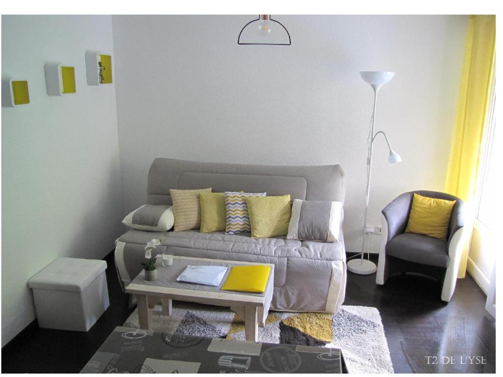ein Wohnzimmer mit einem Sofa und einem Stuhl in der Unterkunft T2 de L'yse in Luz-Saint-Sauveur