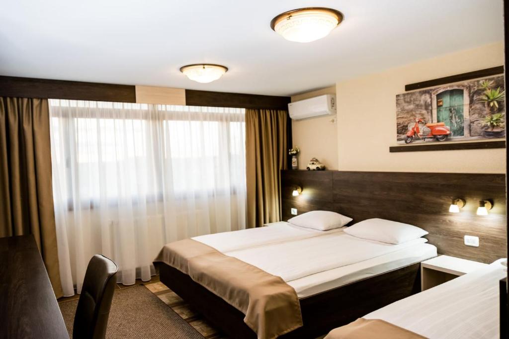 Habitación de hotel con 2 camas y ventana en Domino Residence, en Zimandcuz