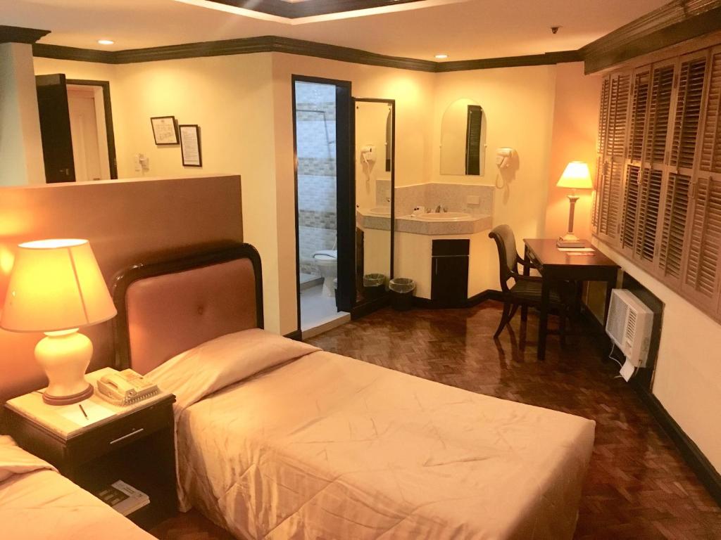 Postel nebo postele na pokoji v ubytování Lourdes Suites Makati powered by Cocotel