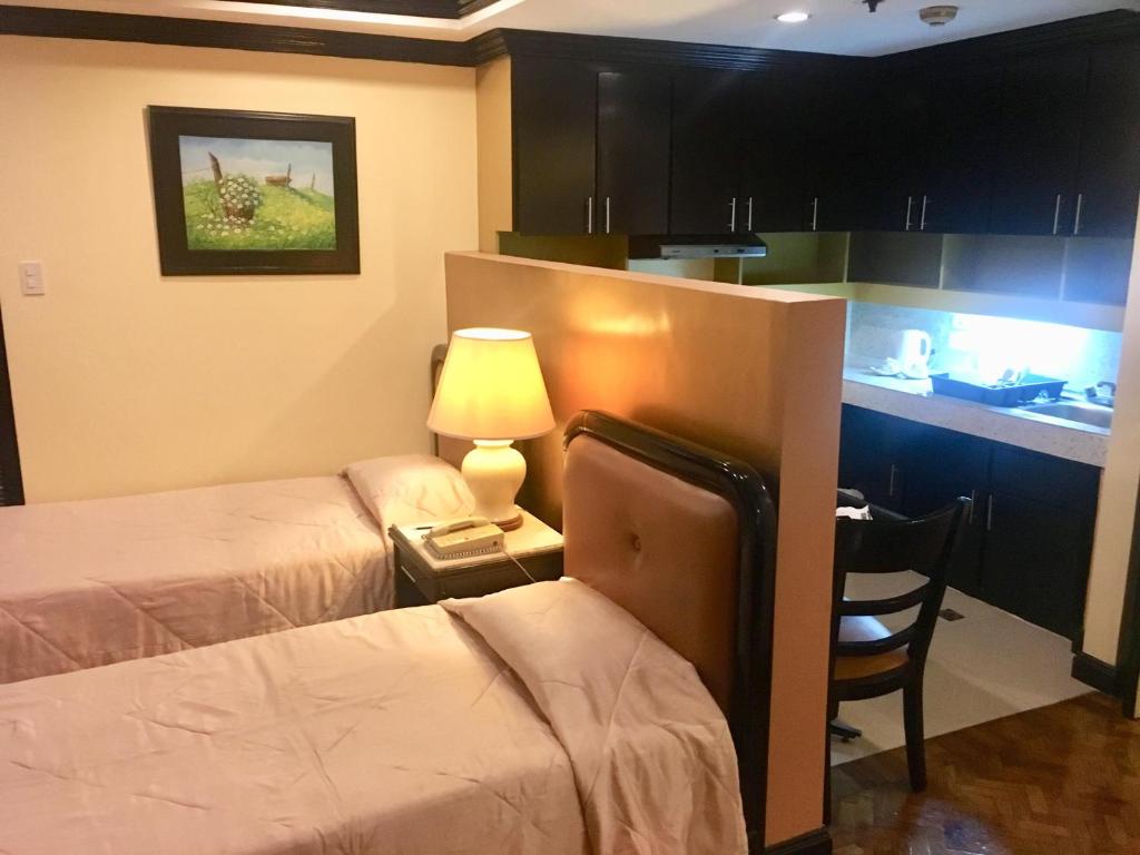 Postel nebo postele na pokoji v ubytování Lourdes Suites Makati powered by Cocotel