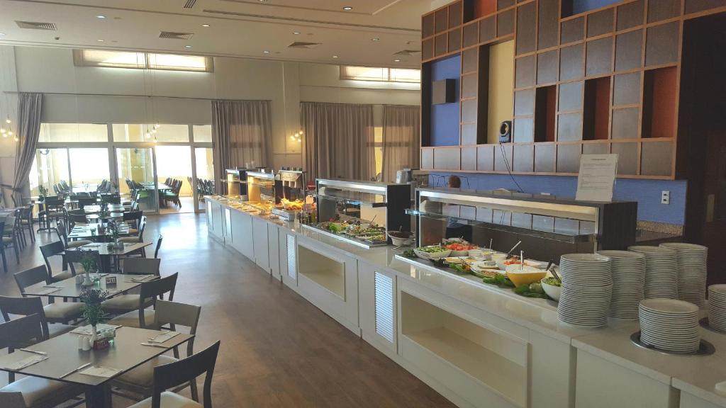 a restaurant with a buffet line with tables and chairs at Aktea Beach Village in Ayia Napa