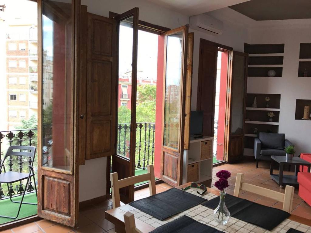 ein Wohnzimmer mit großen Fenstern und einem Tisch mit Blumen in der Unterkunft CALLE CUENCA 2 in Valencia