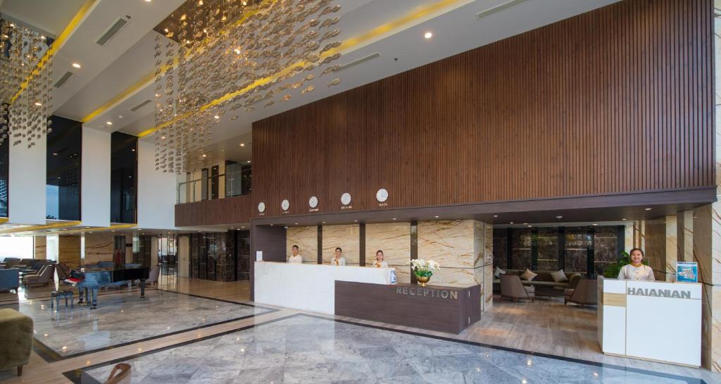 A wide view of the hotel lobby, reception desk, piano, and entrance area.