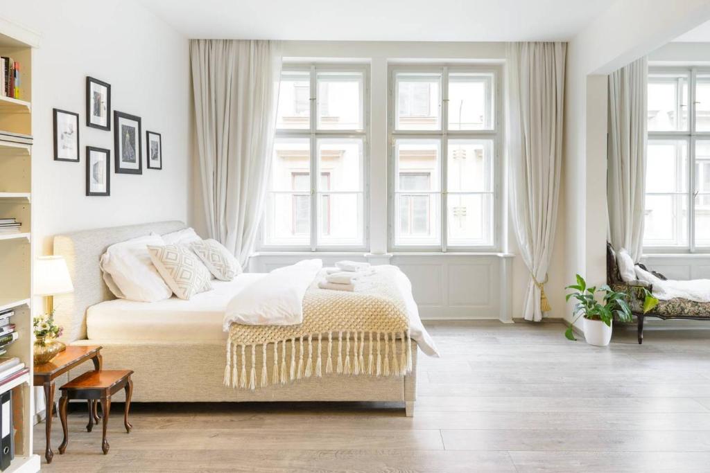 プラハにあるStylish, Light-Filled Home in the Historic Centerの白いベッドルーム(ベッド1台、窓付)