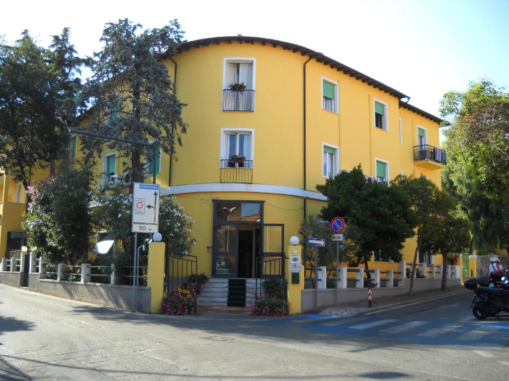 un edificio amarillo al lado de una calle en Hotel La Conchiglia, en Marciana Marina