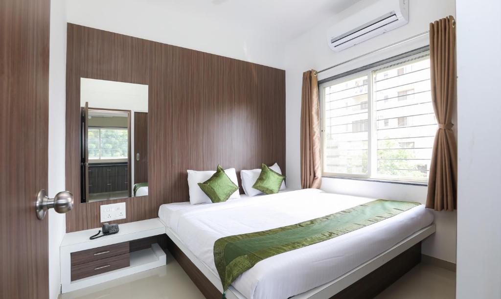 een slaapkamer met een groot bed en een raam bij Treebo Trend Sapphire Studio in Nashik