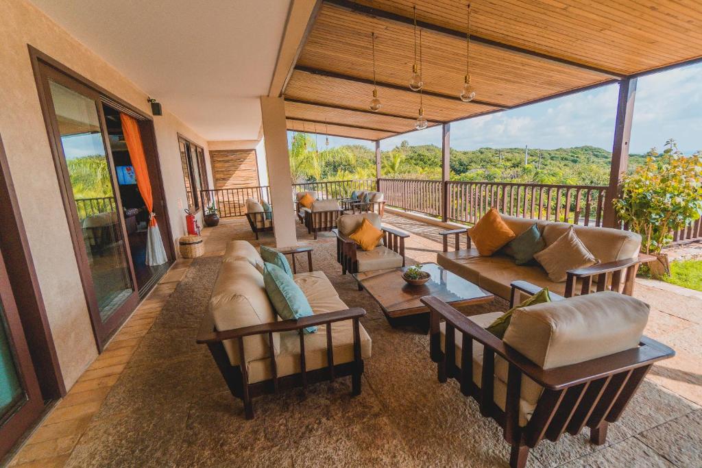 a living room with couches and tables on a deck at Oka Da Mata in Pipa