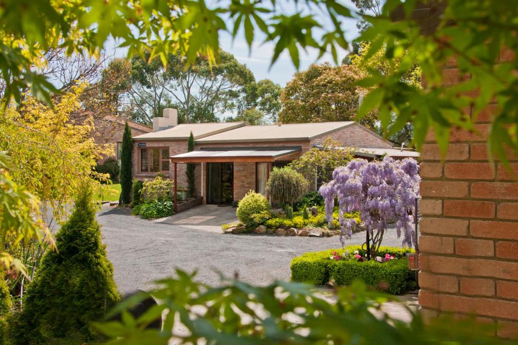 a house with a garden with purple flowers at The Shingles Riverside Cottages in New Norfolk