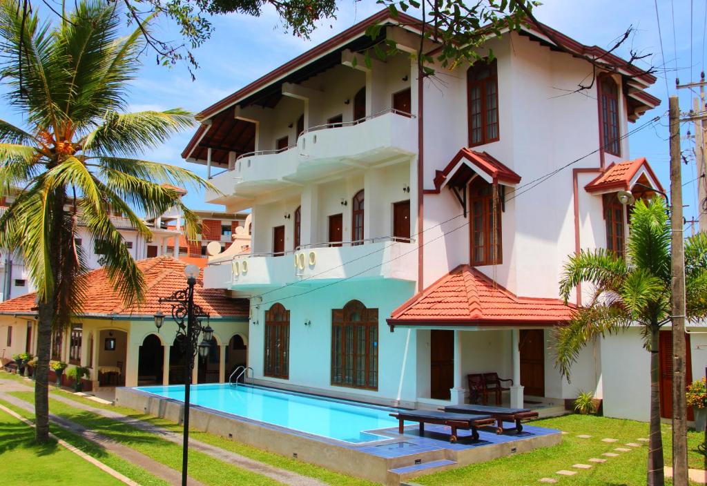 a villa with a swimming pool and a resort at Holiday Fashion Inn in Negombo