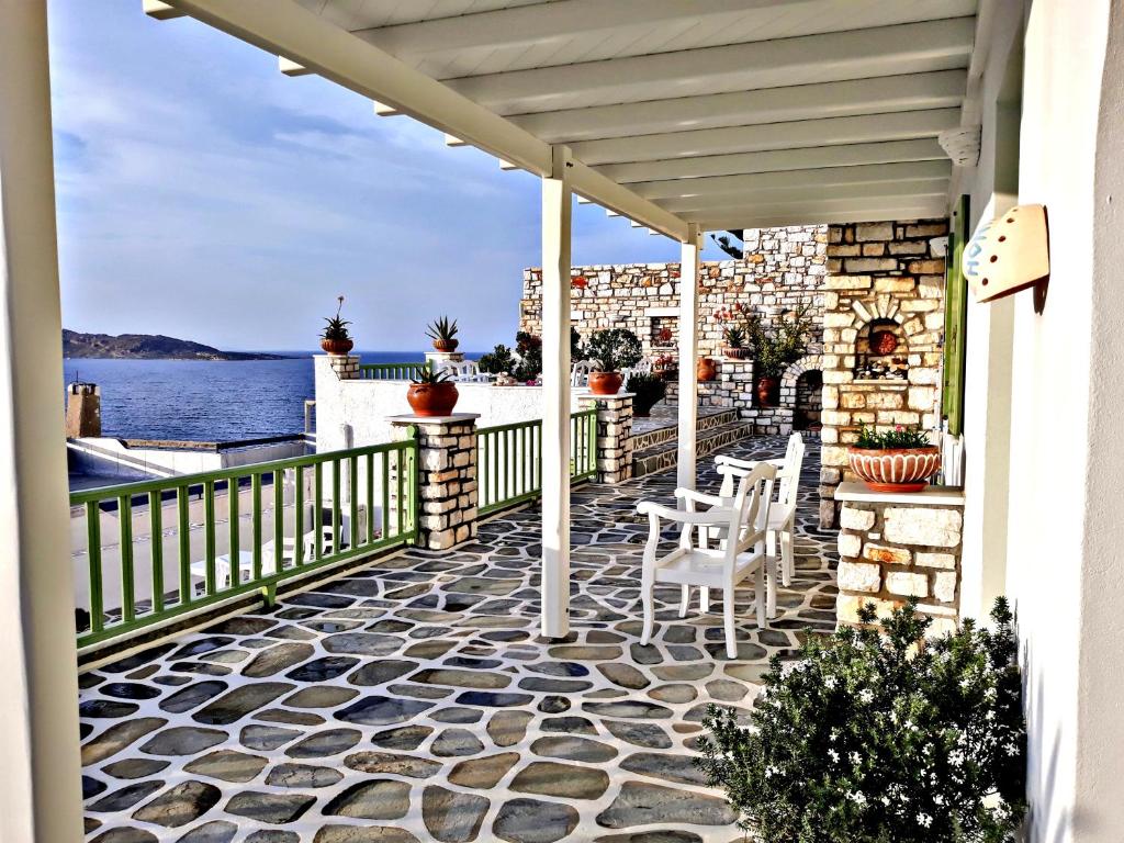 eine Terrasse mit Stühlen und Blick auf das Wasser in der Unterkunft Villa Isabella in Naoussa