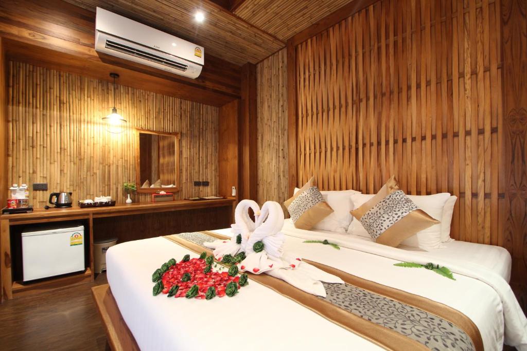 a bedroom with a bed with a flower on it at Railay Village Resort in Railay Beach