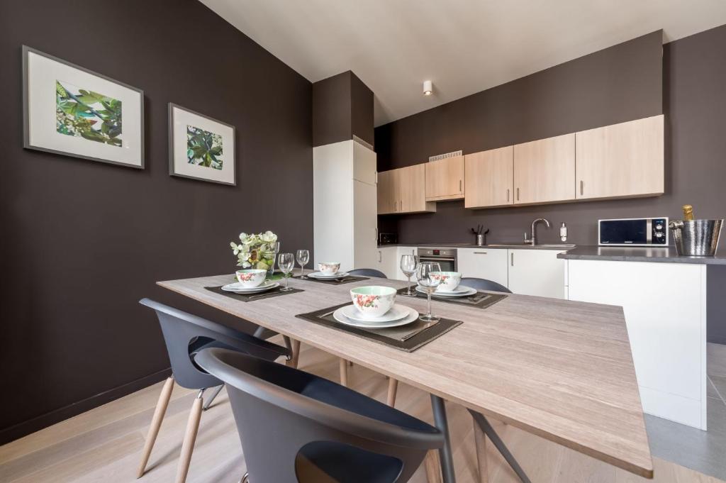 a kitchen with a large wooden table and chairs at Smartflats - Pot d'Or in Liège