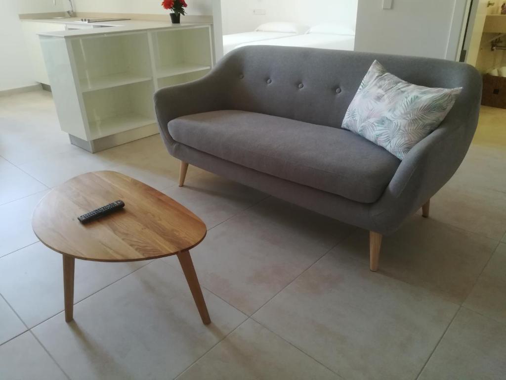 a living room with a couch and a coffee table at Apartamentos Villa Primera in Cala Figuera