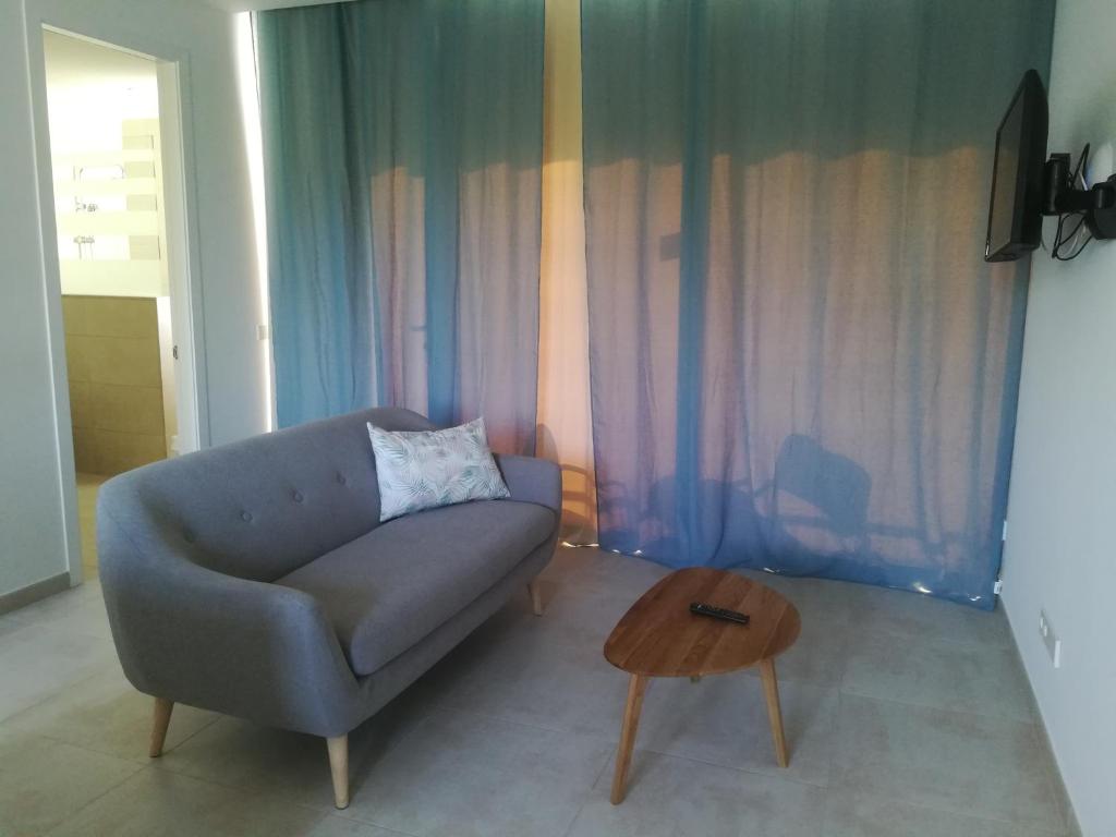 a living room with a couch and a table at Apartamentos Villa Primera in Cala Figuera