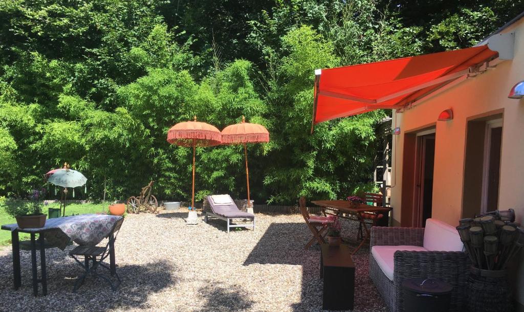 eine Terrasse mit Sonnenschirmen sowie einem Tisch und Stühlen in der Unterkunft House Apricot in Krefeld