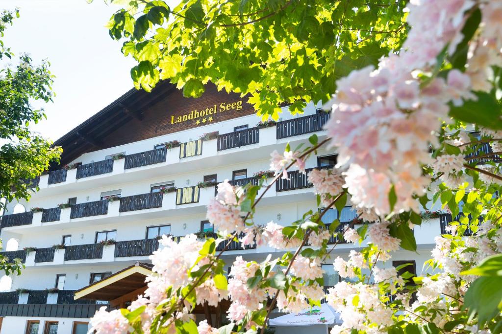 Um edifício com flores cor-de-rosa à frente. em Landhotel Seeg em Seeg