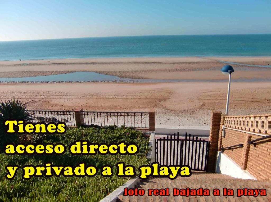 ein Bild eines Strandes mit den Worten zackt Zugangsrichtung und la play in der Unterkunft A la Orilla del Mar in Matalascañas
