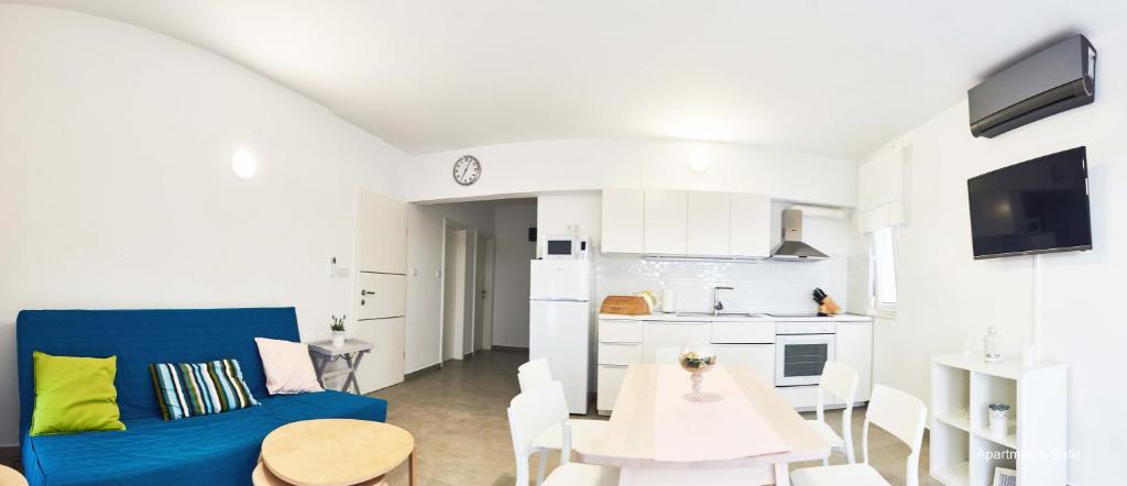 a living room with a blue couch and a table at Salis Apartments in Vrsi